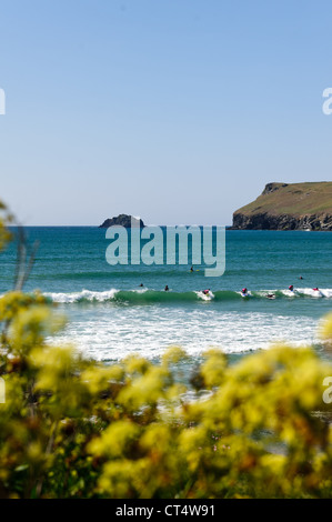 Surfer im Meer warten auf eine Welle an Polzeath Bucht an einem sonnigen Sommertag in Cornwall zu fangen Stockfoto