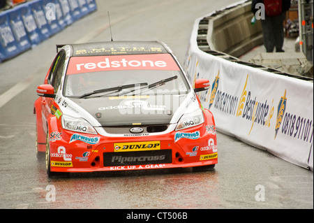 Aron Smith fahren die Redstone Racing Team Tourenwagen auf der Strecke von Dublin Bavaria City Racing Stadtkurs. Stockfoto