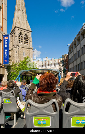 Touristen auf eine "hop on Hop off" City Tour-Bus fahren vorbei an Str. Andrews Kirche, das heute die Tourist Information Centre. Stockfoto