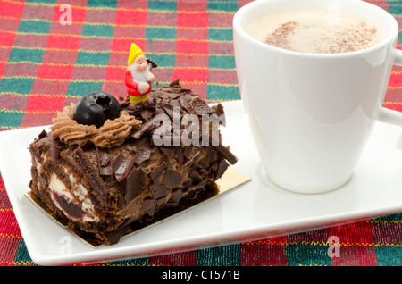 Buchette de Noel mit ein Milchkaffee. Die klassischen Buche de Noel ist die Französisch Weihnachten Kuchen in der Form eines Yule log. Stockfoto