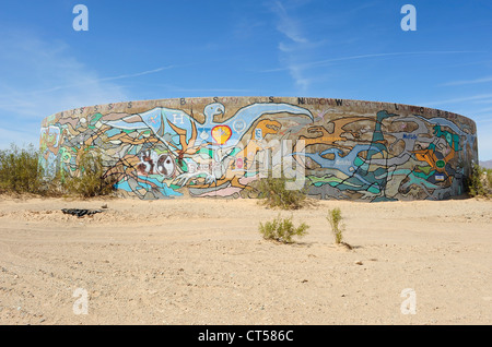 Räder von Kama und Krieg, konkrete Wassertanks gemalt mit Kunstwerken, befindet sich in Slab City, Niland, Southern California, USA. Stockfoto