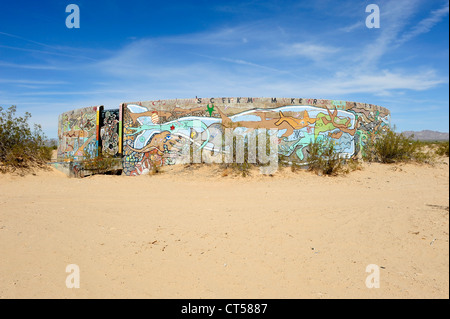 Räder von Kama und Krieg, konkrete Wassertanks gemalt mit Kunstwerken, befindet sich in Slab City, Niland, Southern California, USA. Stockfoto