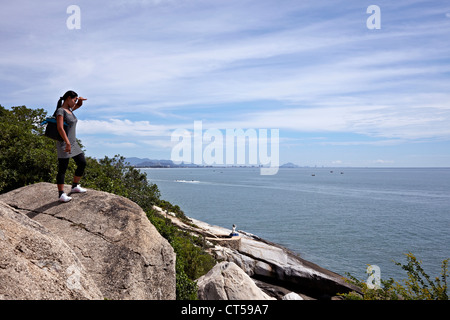 Mit Blick auf das Meer. Weiblicher Tourist mit Blick auf Hua hin entfernte Landschaft und Meer von Khao Takiab erhöhten Aussichtspunkt. Thailand S.E. Asien Stockfoto