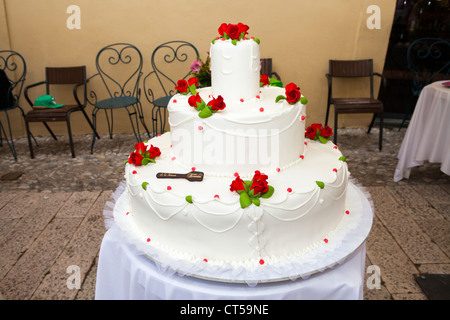 Rote Blumendekorationen auf große Hochzeitstorte Stockfoto