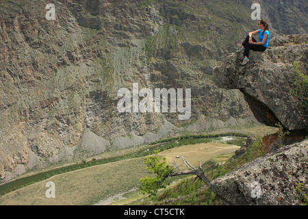 Frau thront auf Felsen am Chulyshman-River-Canyon, Altai, Sibirien, Russland Stockfoto