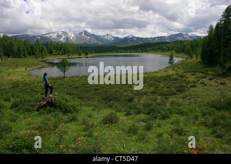 Frau steht auf einem Felsen durch unberührten Bergsee, Ulagansky Pass, Altai, Sibirien, Russland Stockfoto