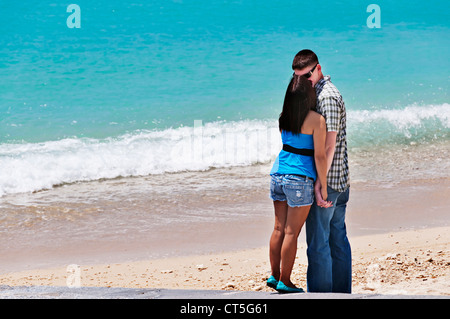 Junge Erwachsene Heterosexuelles Paar umarmt am schönen Sandstrand direkt am Meer in Okinawa, Japan. Stockfoto