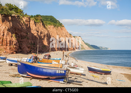 Blaue und braune Fischerboote wurden auf dem Kiesstrand von Klippen in Sidmouth an der Jurassic Coast und dem Ärmelkanal, Devon, England, Großbritannien, befahren Stockfoto