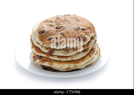 ein Stapel von Scotch Pfannkuchen mit Rosinen oder getrocknete Früchte auf einem Teller isoliert auf weiss Stockfoto