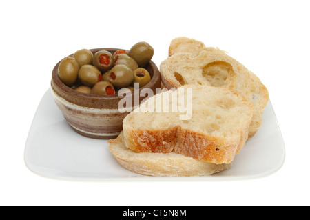 Oliven in einer Schüssel mit Ciabata Brot auf einem Teller isoliert gegen weiß Stockfoto