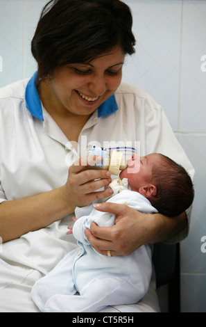 NEUGEBORENE MIT BABY-FLASCHE Stockfoto