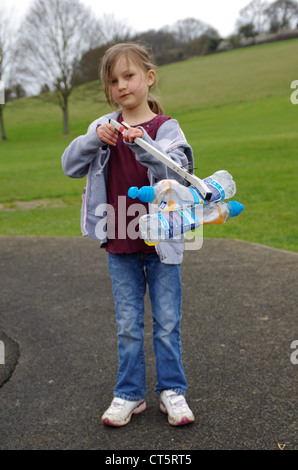 Mädchen Abholung Wurf mit einem Wurf grabbing Tool auf dem Spielplatz ihren lokalen Park. Stockfoto