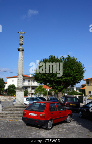 Traditionelle steinkalvarienüberkreuzung oder Cruzeiro auf Platz und geparkten Autos, Vila Praia de Ancora, Nordportugal Stockfoto