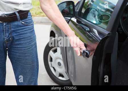 Kaukasischen Mann stehen in der Nähe von Auto und Tür Griff Stockfoto