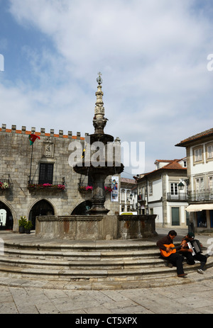 Straßenmusikanten auf Stufen des Chafariz Brunnen, Paco do Concelho Altstädter Rathaus im Hintergrund, Viana do Castelo, Nordportugal Stockfoto