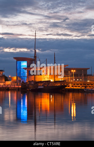 Brixham Fischmarkt in der Abenddämmerung, reflektiert in das Stille Wasser des inner harbour Stockfoto