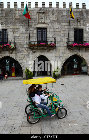 Touristen auf Pedal Fahrzeug vor Paco do Concelho Altstädter Rathaus, Praca da Republica, Viana do Castelo, Nordportugal Stockfoto