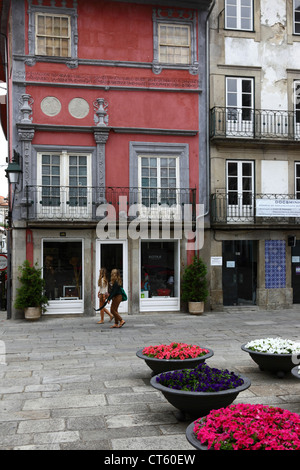 Junge Frauen, die an der Casa de la Luna/Casa dos Lunas und Kapuzinerknotenblumen vorbeilaufen, Viana do Castelo, Nordportugal Stockfoto