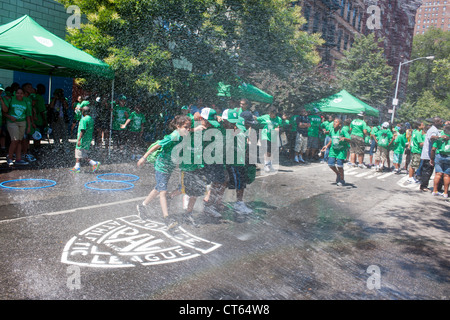 Jugendliche abkühlen mit Wasser besprüht von einem ordnungsgemäß aufgestellter Hydranten bei der Eröffnung des einen Sommer Spielstraße Stockfoto