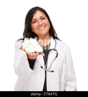 Attraktive Hispanic Frauen Arzt oder Krankenschwester Holding Out Babyschuhe isoliert auf einem weißen Hintergrund. Stockfoto