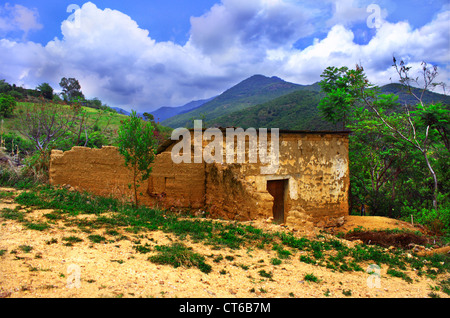 Adobe-Backstein-Haus in Schutt und Asche unter Vegetation und bergige Landschaft in Oaxaca, Mexiko Stockfoto