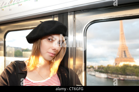 Schöne und glückliche junge Frau in Paris u-Bahn. Eiffel-Turm durch das Zugfenster gesehen. Paris, Frankreich, Europa. Stockfoto