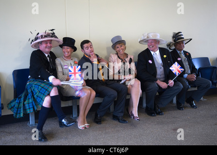 Männer, die Frauen mit Frauenmützen tragen. Royal Ascot Pferderennen Berkshire. Spaß nach einem fröhlichen Tag bei den Rennen. HOMER SYKES AUS DEN 2012 2010ER JAHREN Stockfoto