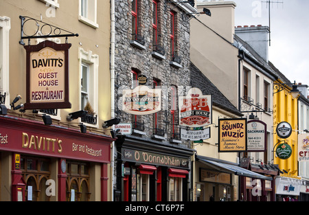 Mehrfarbige Ladenfronten mit interessanten Straßenschilder in Kenmare, County Kerry, Irland Stockfoto