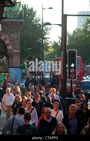 Fußgänger zu Fuß entlang einer belebten Straße im Zentrum der City of London, England. Stockfoto