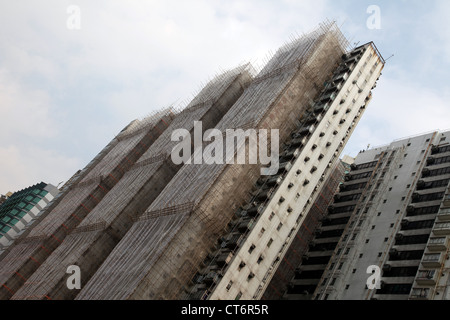 Es ist ein Foto von einem Hochhaus im Bau in Hong Kong, China. Wir sehen die Bambus-Gerüste gegen den Bau Stockfoto
