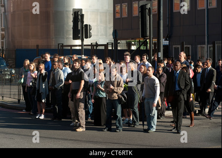 Fußgänger warten auf eine belebten Straße im Zentrum der City of London, England zu überqueren. Stockfoto