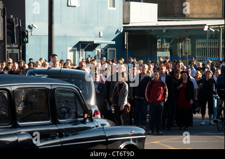 Fußgänger warten auf eine belebten Straße im Zentrum der City of London, England zu überqueren. Stockfoto