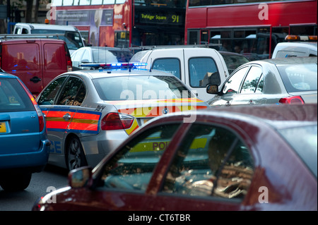 Ein Polizeiauto mit blau blinkende Lichter versucht, seinen Weg durch dichten Verkehr im Zentrum von London, England. Stockfoto