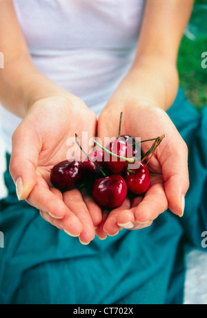 Eine junge Frau mit einer Handvoll Kirschen. Stockfoto