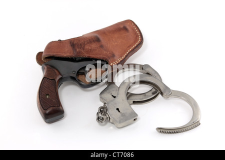 Vintage Revolver in Lederholster mit Handschellen auf weißem Hintergrund Stockfoto