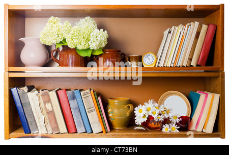 Ländliches Dorf Bücherregal mit alten gebrochenen Büchern, Keramik Töpfe, Uhren und Gänseblümchen Blumen. Isoliert. Fromt Ansicht Stockfoto