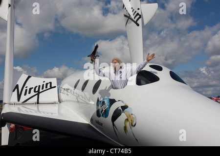 Neben seiner SpaceShipTwo Fahrzeug hält Richard Branson Modell des Satelliten LauncherOne nach Virgin Galactic Space Tourismus-Präsentation auf der Farnborough Air Show. Stockfoto