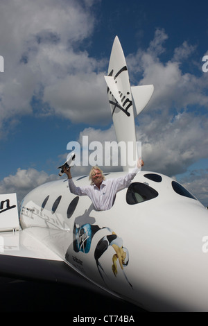 Neben seiner SpaceShipTwo Fahrzeug hält Richard Branson Modell des Satelliten LauncherOne nach Virgin Galactic Space Tourismus-Präsentation auf der Farnborough Air Show. Stockfoto