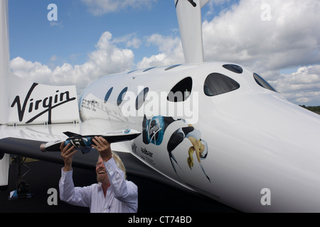 Neben seiner SpaceShipTwo Fahrzeug hält Richard Branson Modell des Satelliten LauncherOne nach Virgin Galactic Space Tourismus-Präsentation auf der Farnborough Air Show. Stockfoto