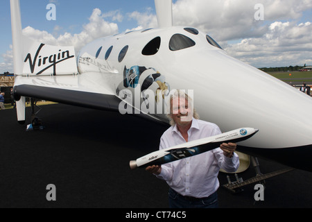 Neben seiner SpaceShipTwo Fahrzeug hält Richard Branson Modell des Satelliten LauncherOne nach Virgin Galactic Space Tourismus-Präsentation auf der Farnborough Air Show. Stockfoto