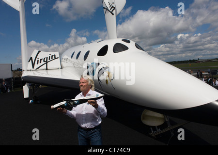 Neben seiner SpaceShipTwo Fahrzeug hält Richard Branson Modell des Satelliten LauncherOne nach Virgin Galactic Space Tourismus-Präsentation auf der Farnborough Air Show. Stockfoto