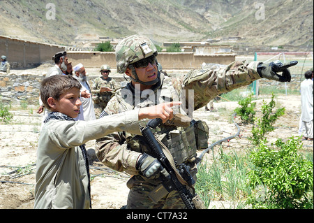 Soldat der US Army spricht zu einem lokalen Teenager über den Standort seiner Schule bei einem Besuch in der zentralen Kunar Demo Farm 21. Juni 2012 in Kunar, Afghanistan. Der Soldat ist Bestandteil der provinzielle Rekonstruktion Team Kunar landwirtschaftlichen Bereich, die Unterstützungsleistungen der Demo-Farm, die Bauern und andere einheimische in der Nähe effektivere Wege zu Pflanzen anbauen zu zeigen. Stockfoto