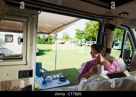 Reife Frau liest in Wohnmobil Stockfoto