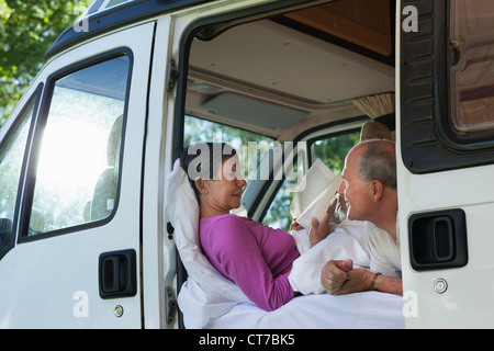 Paar im Wohnmobil, Frau liest Stockfoto