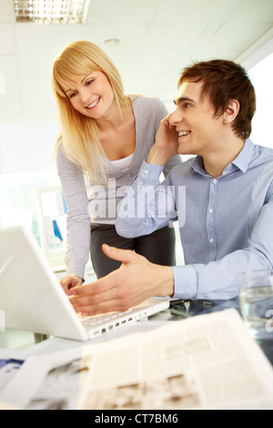 Bild von glücklichen Menschen sprechen am Telefon während seiner Sekretärin Blick auf Laptop in der Nähe von im Büro Stockfoto