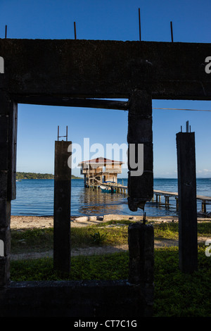 Wasser nach Hause umrahmt von unvollständigen Bau auf Isla Carenero, Archipel Bocas del Toro, Panama. Stockfoto