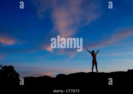 Junge Frau in Wüste mit Armen offen, silhouette Stockfoto