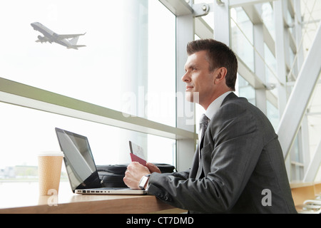 Geschäftsmann mit Laptop in Flughafen Stockfoto