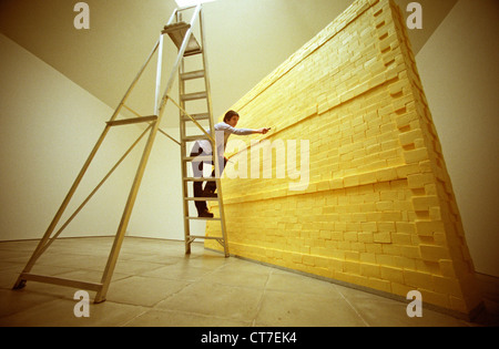 Künstlerin auf Leiter, Bildhauerei eine Wand komplett aus Butter gemacht. Es wog Dreiviertel Tonne und wurde mit Lotto Geld finanziert. Stockfoto