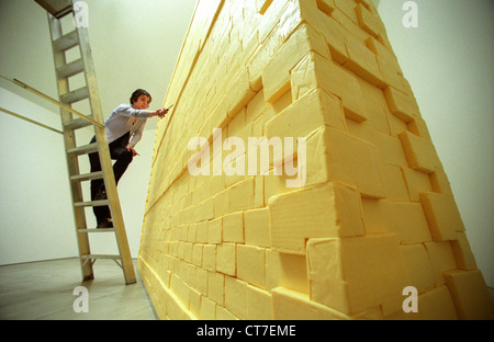 Künstlerin auf Leiter, Bildhauerei eine Wand komplett aus Butter gemacht. Es wog Dreiviertel Tonne und wurde mit Lotto Geld finanziert. Stockfoto